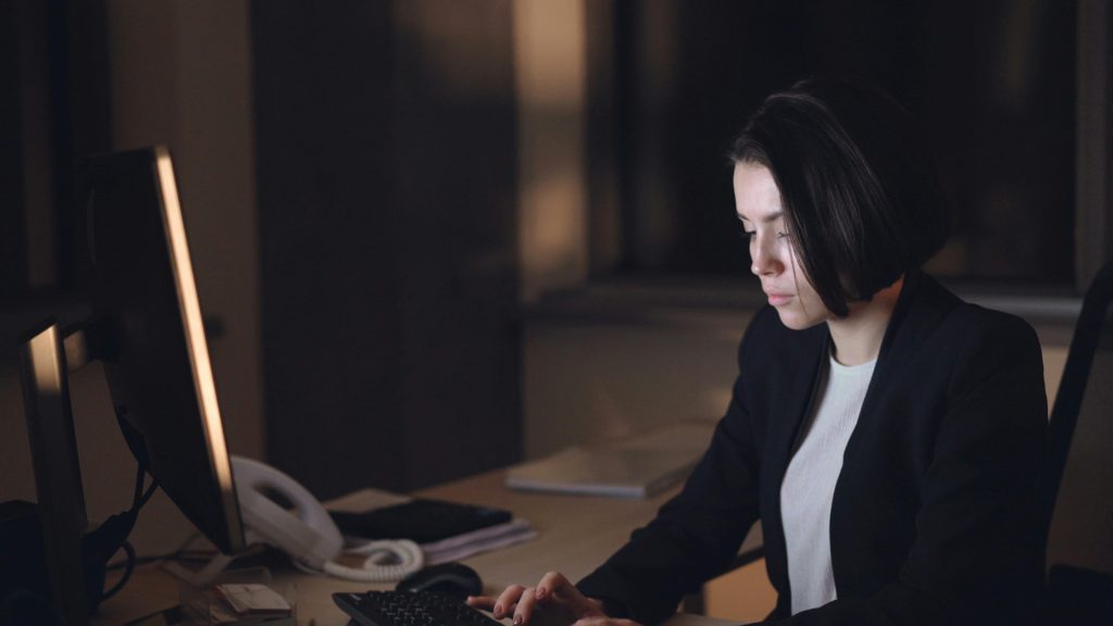 Limo dispatcher working at night managing bookings on computer screen