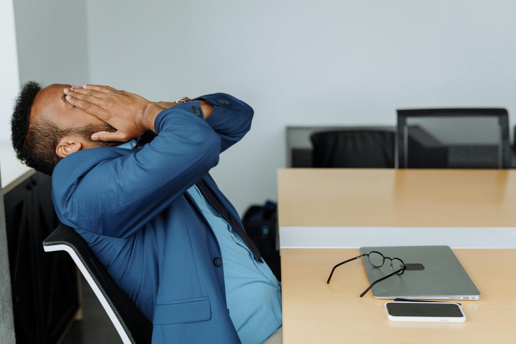 Small business owner looking relieved at desk after delegating tasks to virtual assistant